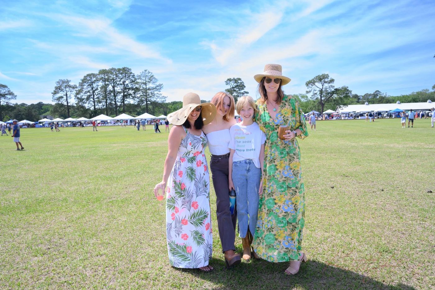 Guests in spring dresses and sun hats on the polo field