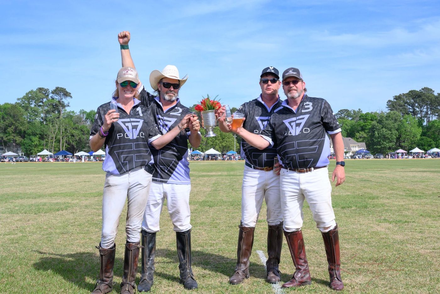 The winning team celebrating with trophies and Champagne